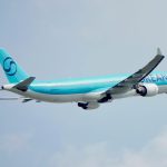 commercial airliner soaring in clear blue sky