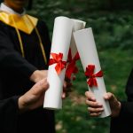 photograph of people s hands holding white diplomas